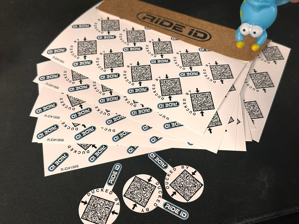RideID Duck Tag sheets with a kraft envelope, loose Duck Tags, and a rubber duck